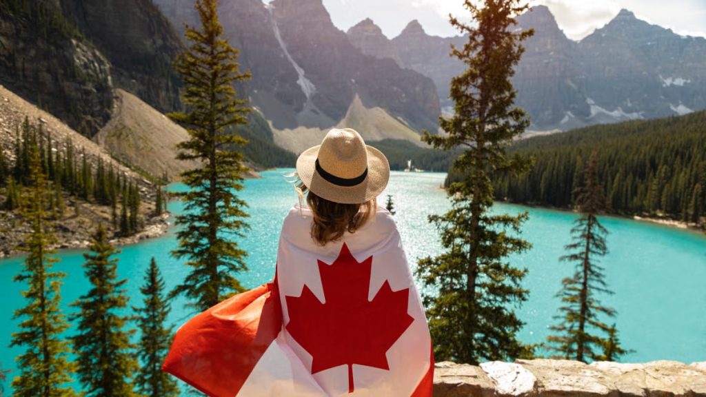 Explore the beauty of Moraine Lake in Alberta, Canada, with a stunning view and a Canadian flag.
